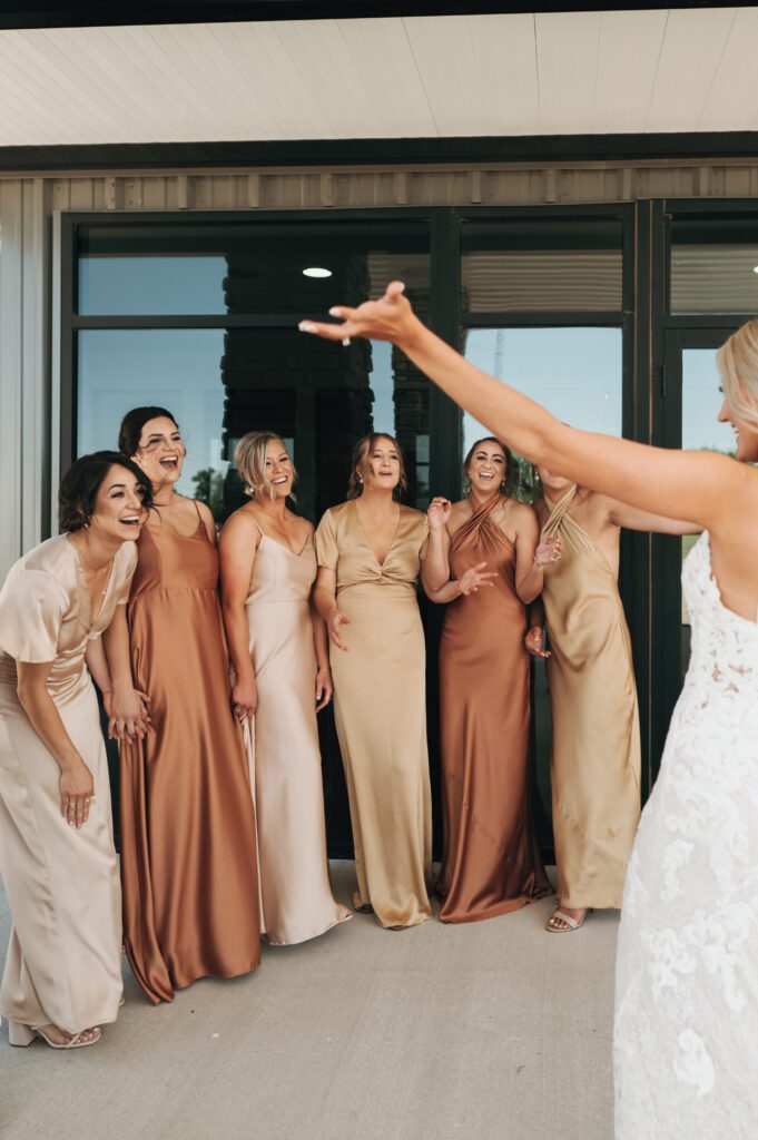 bridesmaids cry and cheer as they see their best friend for first time on wedding day