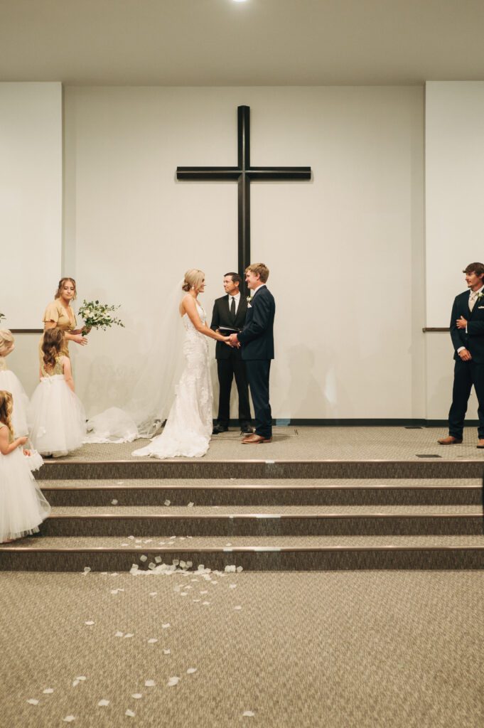 Bride and groom hold hands and exchange vows during their wedding ceremony