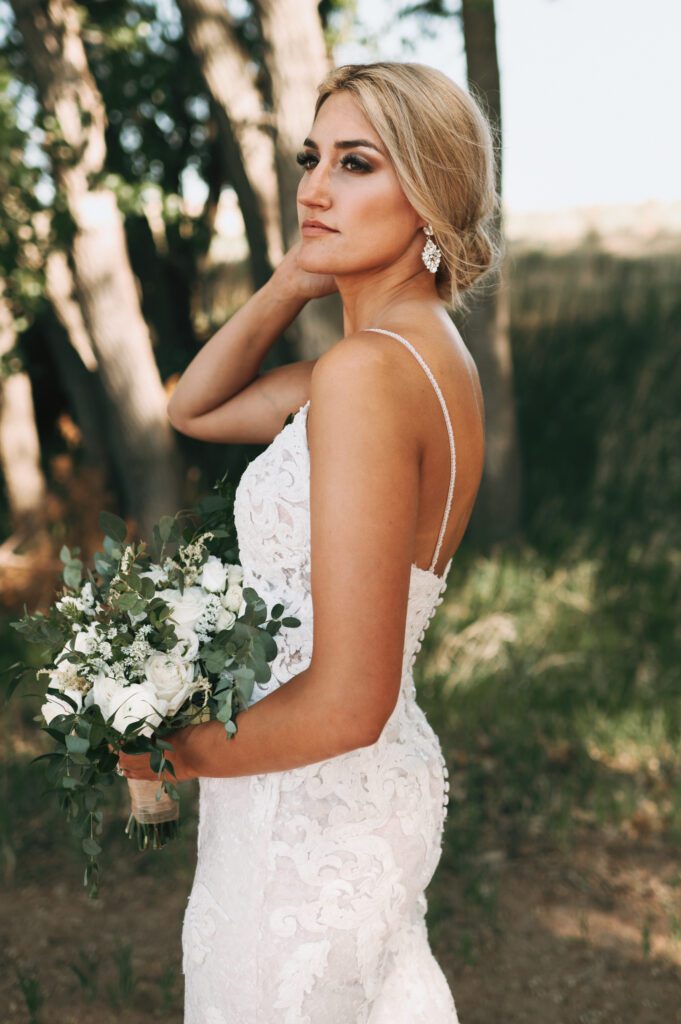 bride looks off in distance for portrait while holding her timeless bouquet of flowers