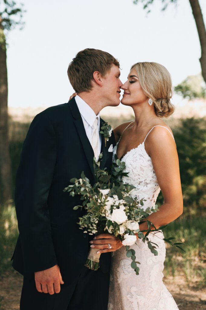 bride and groom touch noses in a romantic way for wedding photo