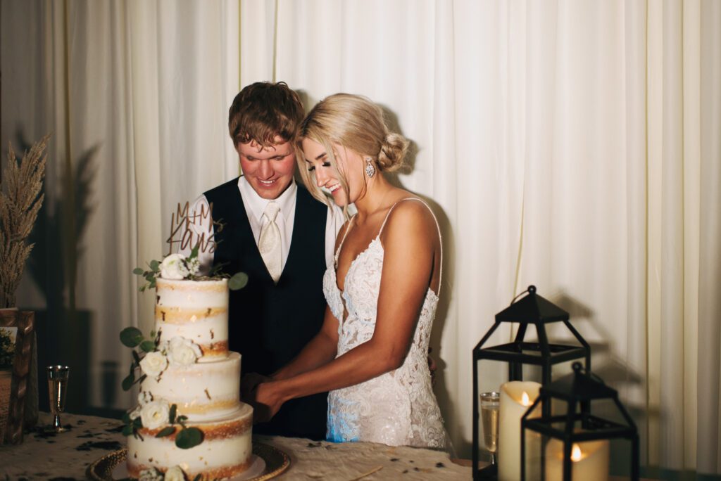 bride and groom cut their three tiered cake