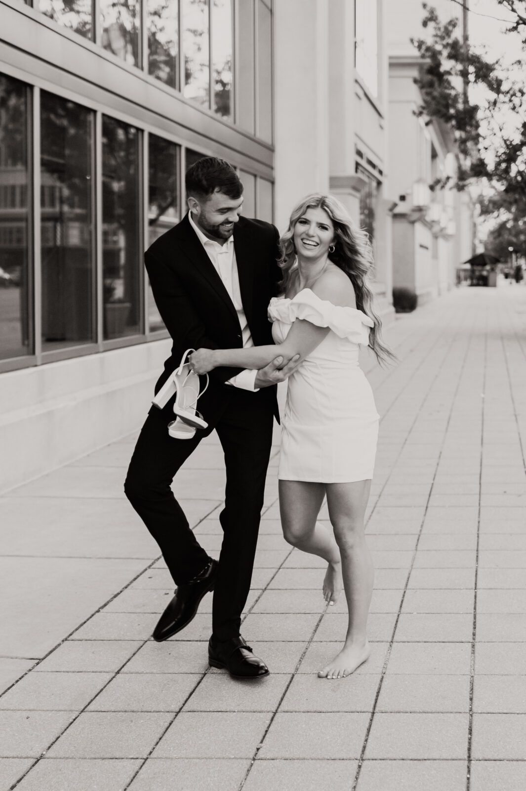 bride to be takes off her heels and runs into her significant other smiling big