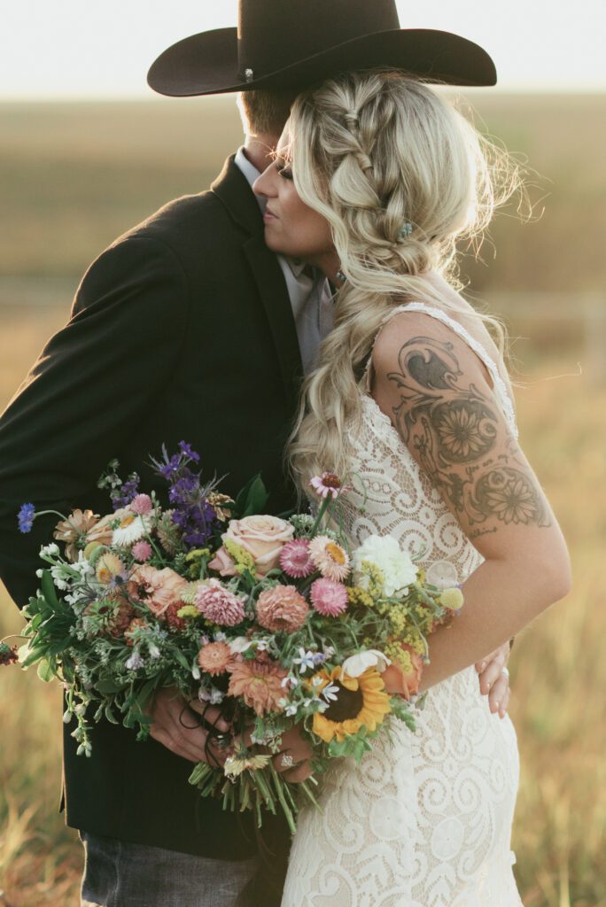 brides braided hair and wildflower flower bouquet